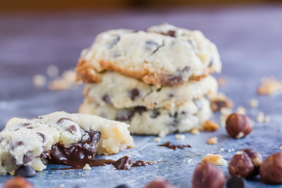 a stack of chocolate chip cookies with one cookie in front