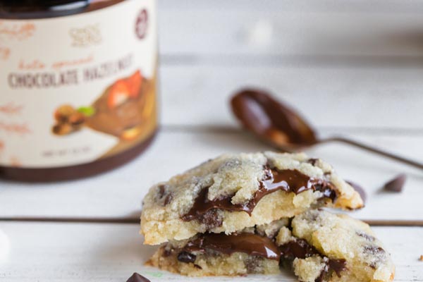 a stack of nutella filled cookies on a white wooden board