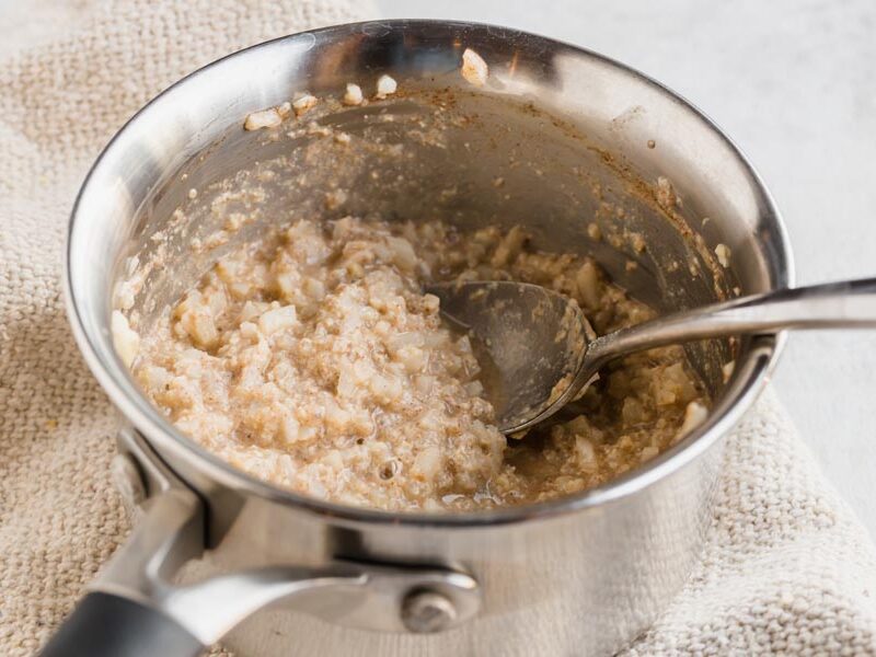 A small pot with cooked keto oatmeal inside mixed with cinnamon.
