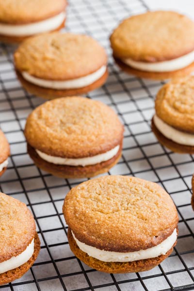 Rows of oatmeal cream pies on a black wire cooling rack.