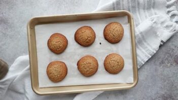 Cookies baked on a tray with crinkle tops.