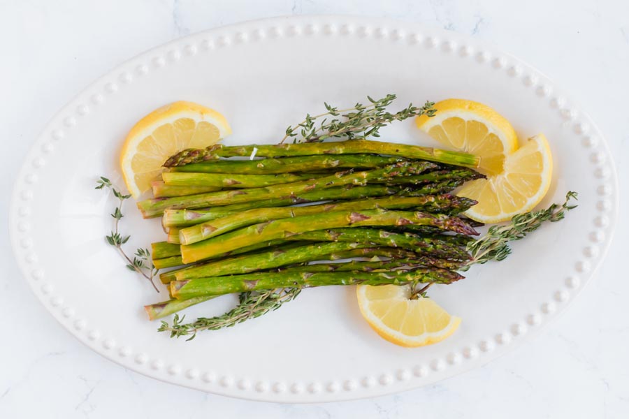 overhead view of asparagus on a platter with lemon