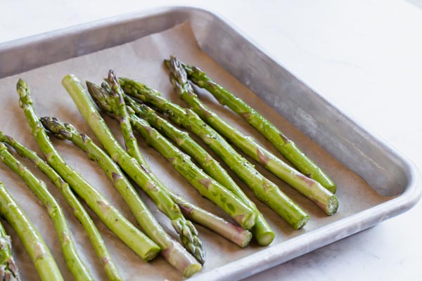 seasoned asparagus on a baking tray