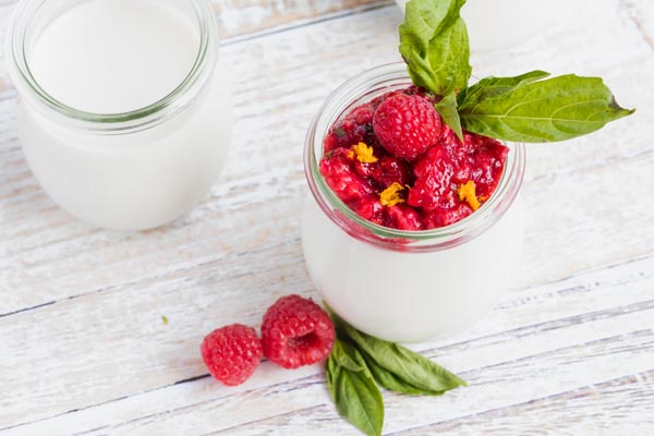 creamy white panna cotta topped with basil leaves and raspberries