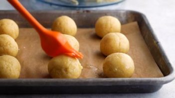 bread dough balls with a basting brush