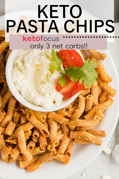 keto pasta chips on a plate with a white dip decorated with tomato slices