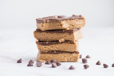 a stack of peanut butter bars with a bite out of the top one