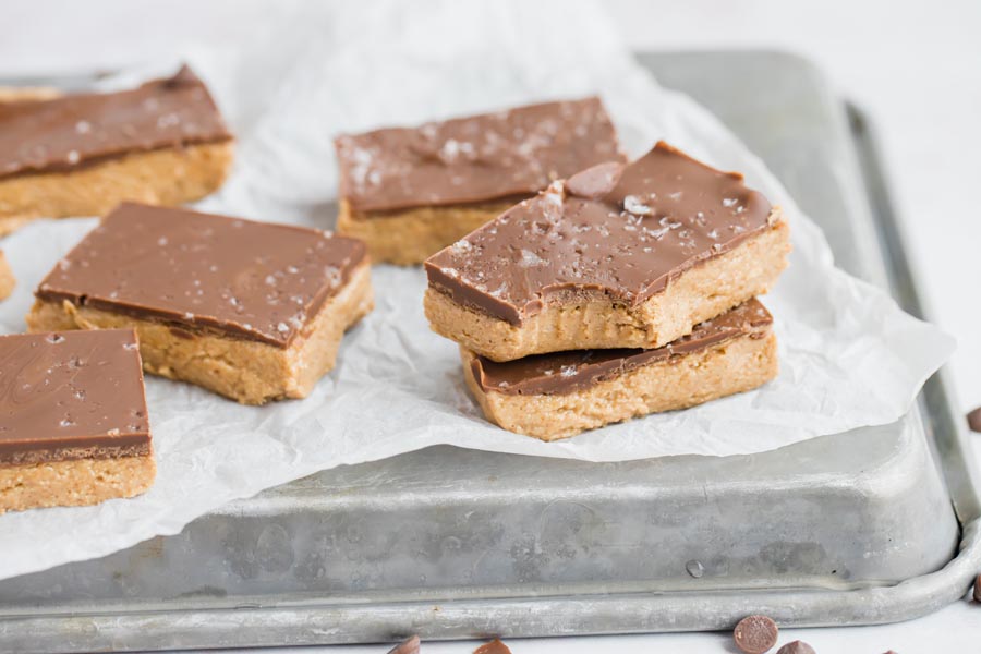 chocolate peanut butter bars laying on parchment and an upside down tray