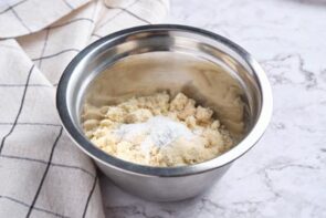 A stainless steel bowl with dry ingredients inside.