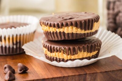 Stacked keto peanut butter cups with chocolate coating and thick peanut butter centers.
