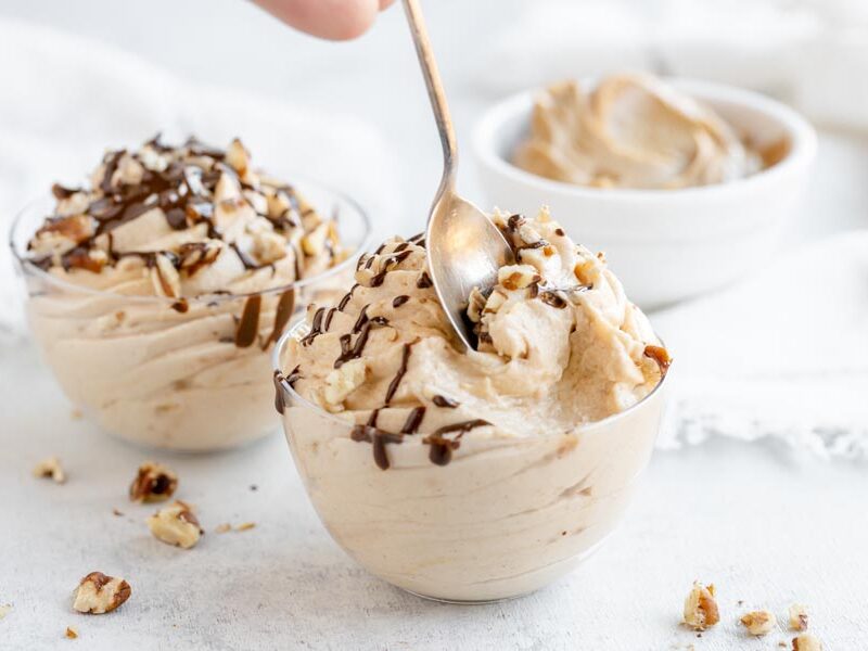 scooping a bite of peanut butter mousse out of a small bowl with another bowl behind