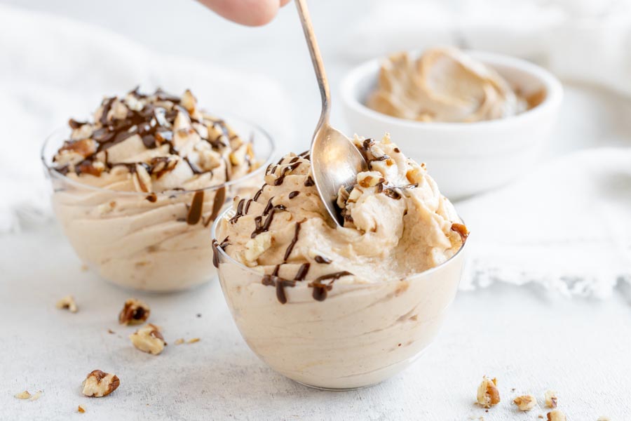 scooping a bite of peanut butter mousse out of a small bowl with another bowl behind