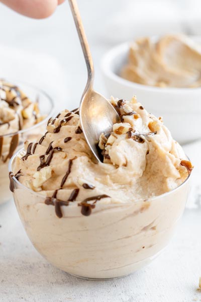 a spoon digging into a bowl of creamy peanut butter mousse
