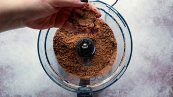a food processor with crumbled crust in it