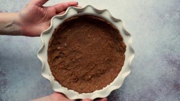 holding a pie plate with crust inside