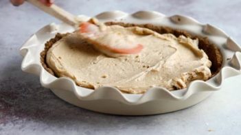 spreading peanut butter mixture in a pie