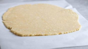 pie crust cookie dough rolled out on a sheet of parchment paper
