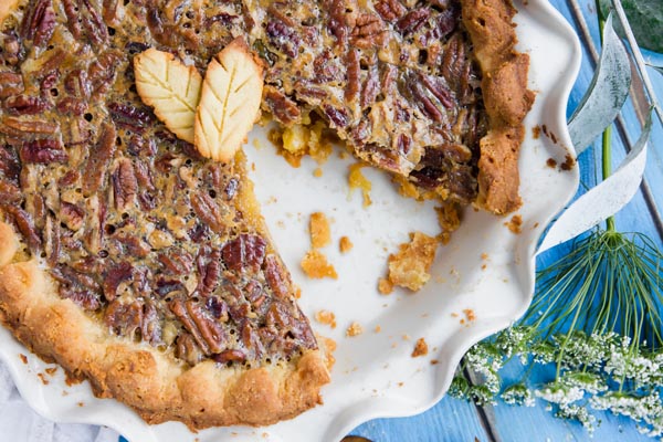 a slice missing from a whole pecan pie