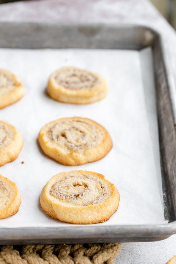 pinwheel cookies laying on a parchment lined baking tray