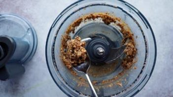 holding a spoon with sticky maple pecan filling in it