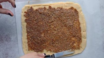 spreading maple pecan filling onto cookie dough