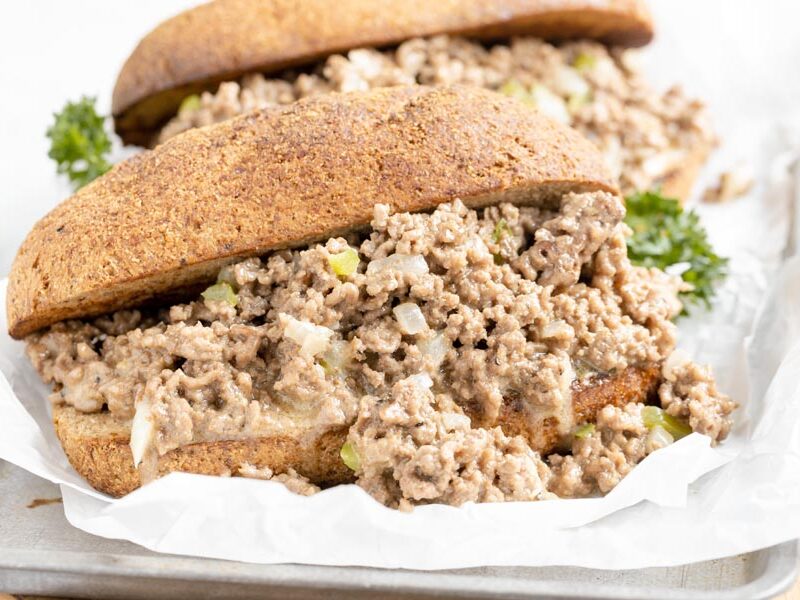 two large philly cheesesteaks with the filling spilling out in front