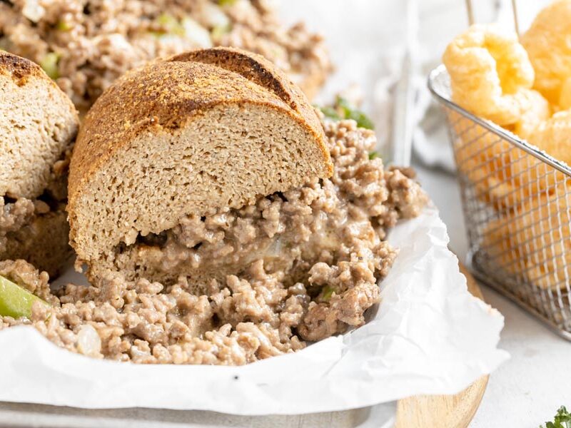 a philly cheesesteak sandwich cut in half and filled with ground beef