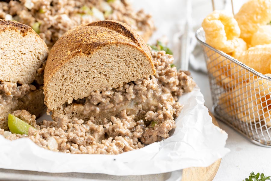 a philly cheesesteak sandwich cut in half and filled with ground beef