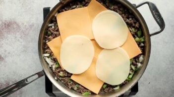 slices of provolone and american cheese on top of a skillet