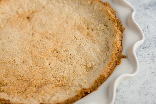 golden brown keto pie crust in a white plate plate