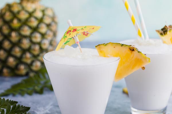frozen pina colada with a yellow umbrella and a pineapple in the background