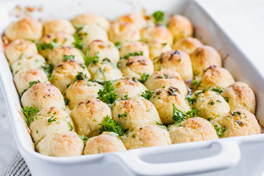 a casserole with rolls on top sprinkled with parsley