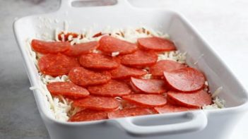 pepperoni slices layers in a casserole dish