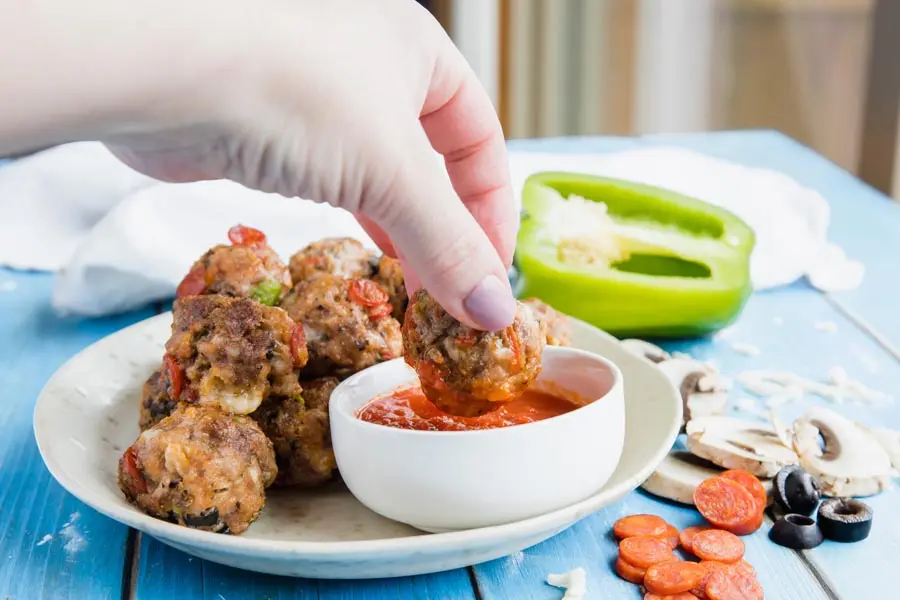 dipping a pizza meatball in low carb pizza sauce