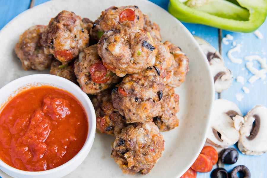 piles of keto pizza meatballs on a plate with mushrooms and bell pepper