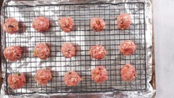 pizza meatballs on a baking tray with a wire rack