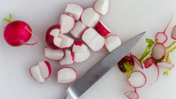 radishes sliced in half with knife