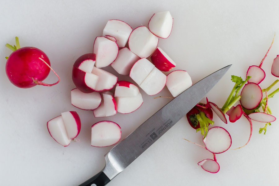 radishes sliced in half with knife