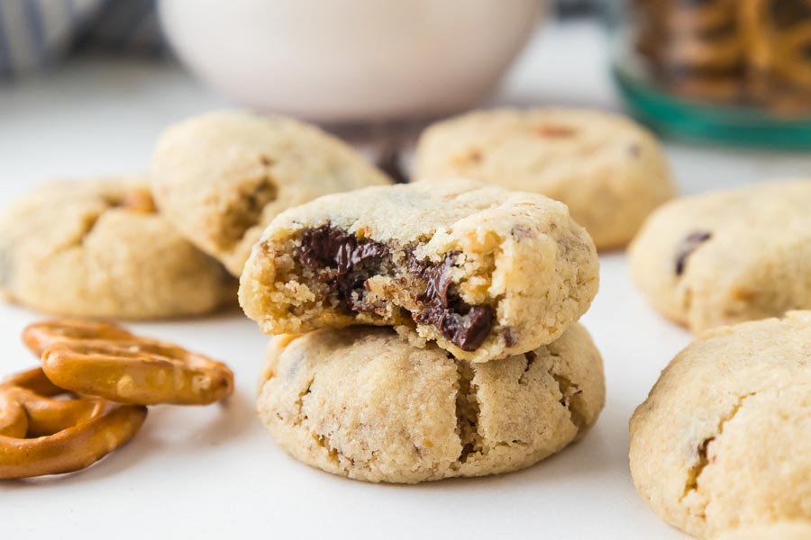 Keto pretzel chocolate chip cookies with a broken cookie showing melted chocolate inside.