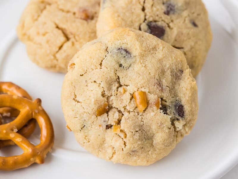 A close-up of a single keto pretzel chocolate chip cookie highlighting visible pretzel chunks and chocolate chips.