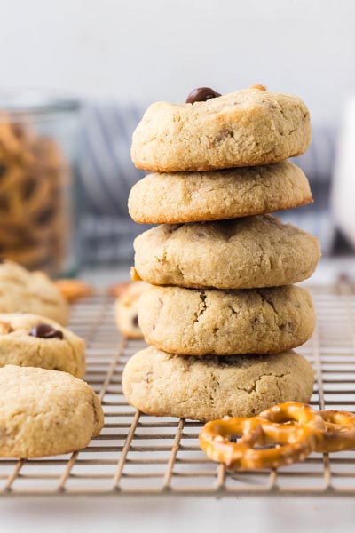 A vertical stack of keto pretzel chocolate chip cookies on a cooling rack, showing their thick, soft texture.
