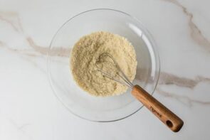 A bowl of dry keto cookie ingredients is whisked together until evenly combined.