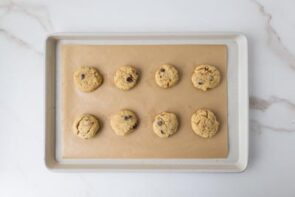 Baked cookies are arranged on a parchment-lined baking sheet.
