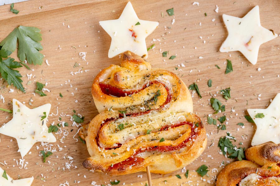 A Christmas appetizer of a pizza tree made of dough, cheese and pepperoni and topped with a cheese star.