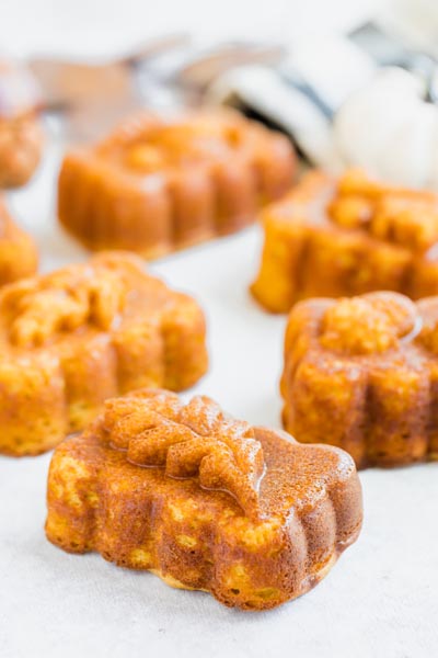 Mini pumpkin loaves on a table with leaves imprinted on them.