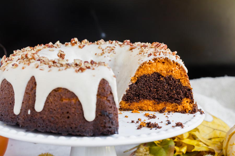 a bundt cake cut showing the layers of orange pumpkin and chocolate