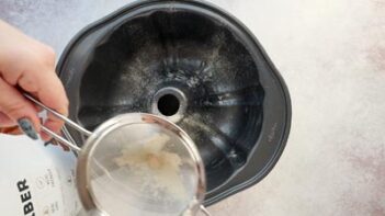 using a mesh to dust a bundt pan with flour