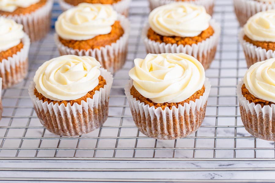 muffins on a wire rack with frosting on them