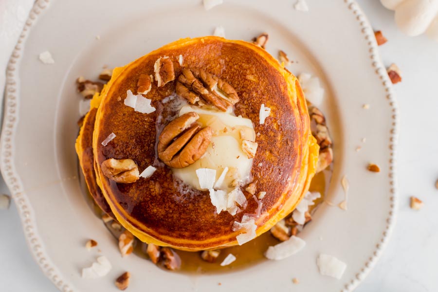 overhead view of low carb pumpkin pancakes with nuts and coconut