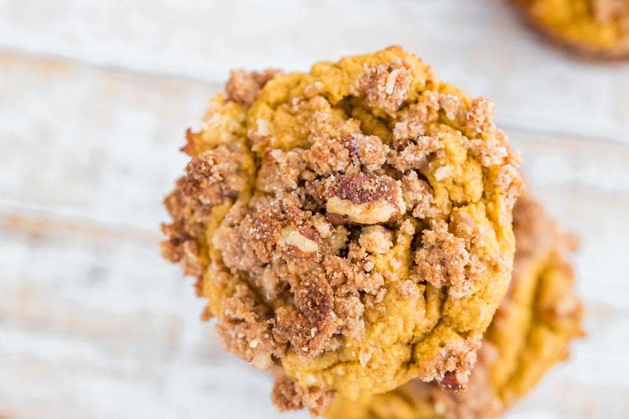 big fluffy baked keto pumpkin muffin with pecan streusel topping